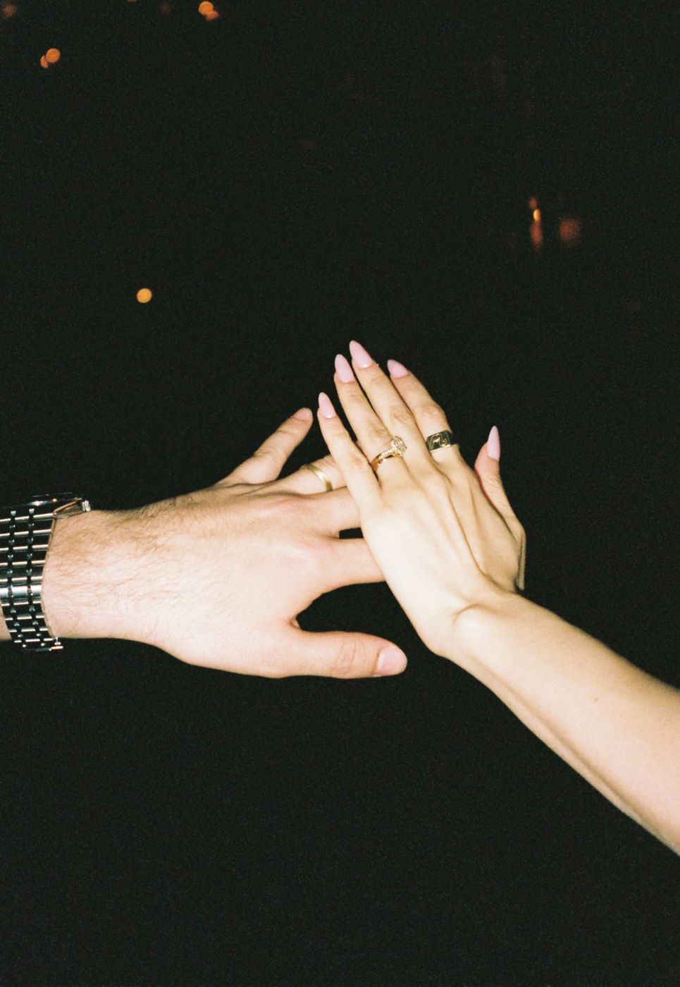 Hands with wedding rings at night