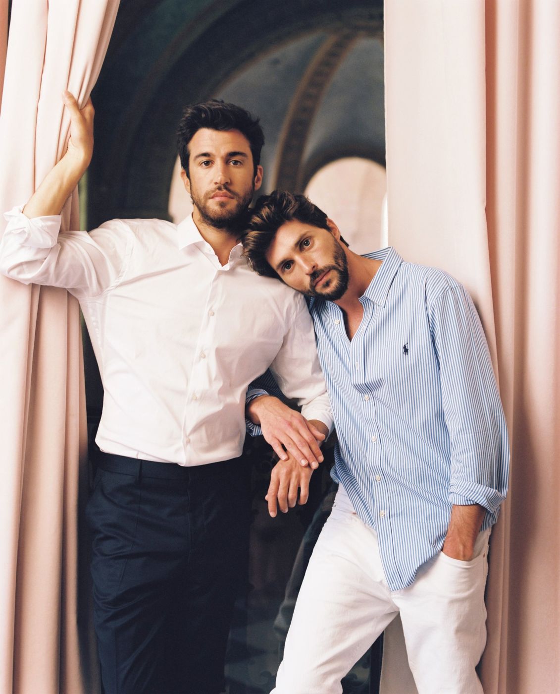 Two grooms by a pink curtain