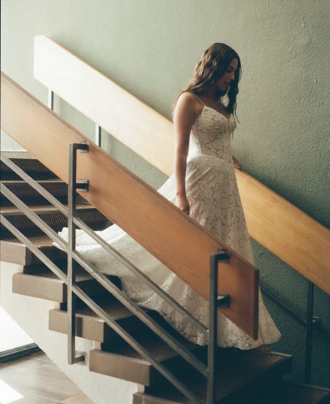 A bride walking down the stairs in lace